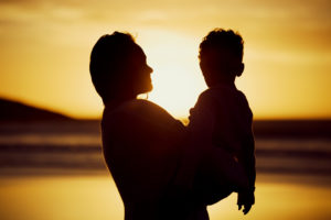 Silhouette, mother and son with hug, beach and vacation with adventure, holiday and getaway trip. Sunset, seaside and single parent with boy, childhood and love with embrace, time together and travel