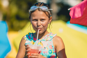 Little girl drinking cocktail on the beach